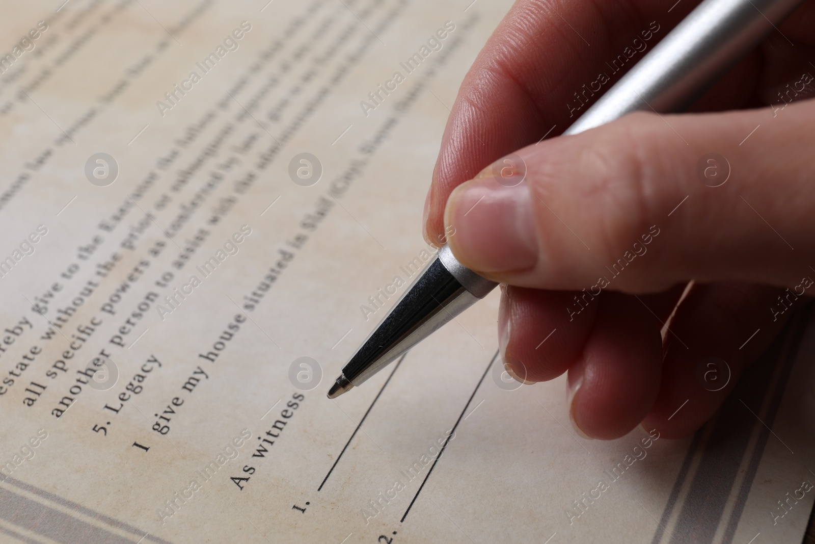 Photo of Woman signing Last Will and Testament at table, closeup