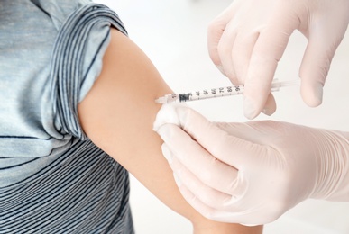 Doctor vaccinating little boy in hospital