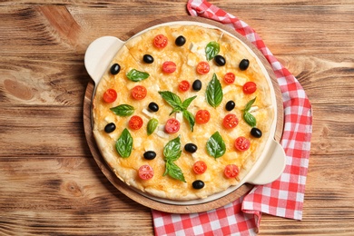 Fresh tasty homemade pizza on wooden background, top view