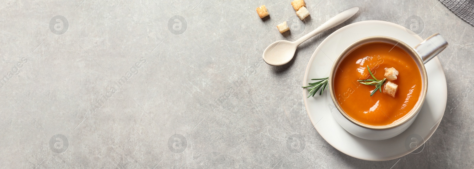 Image of Tasty sweet potato soup on light grey table, flat lay with space for text. Banner design