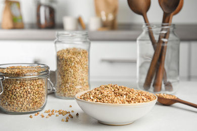 Photo of Uncooked green buckwheat grains on white table