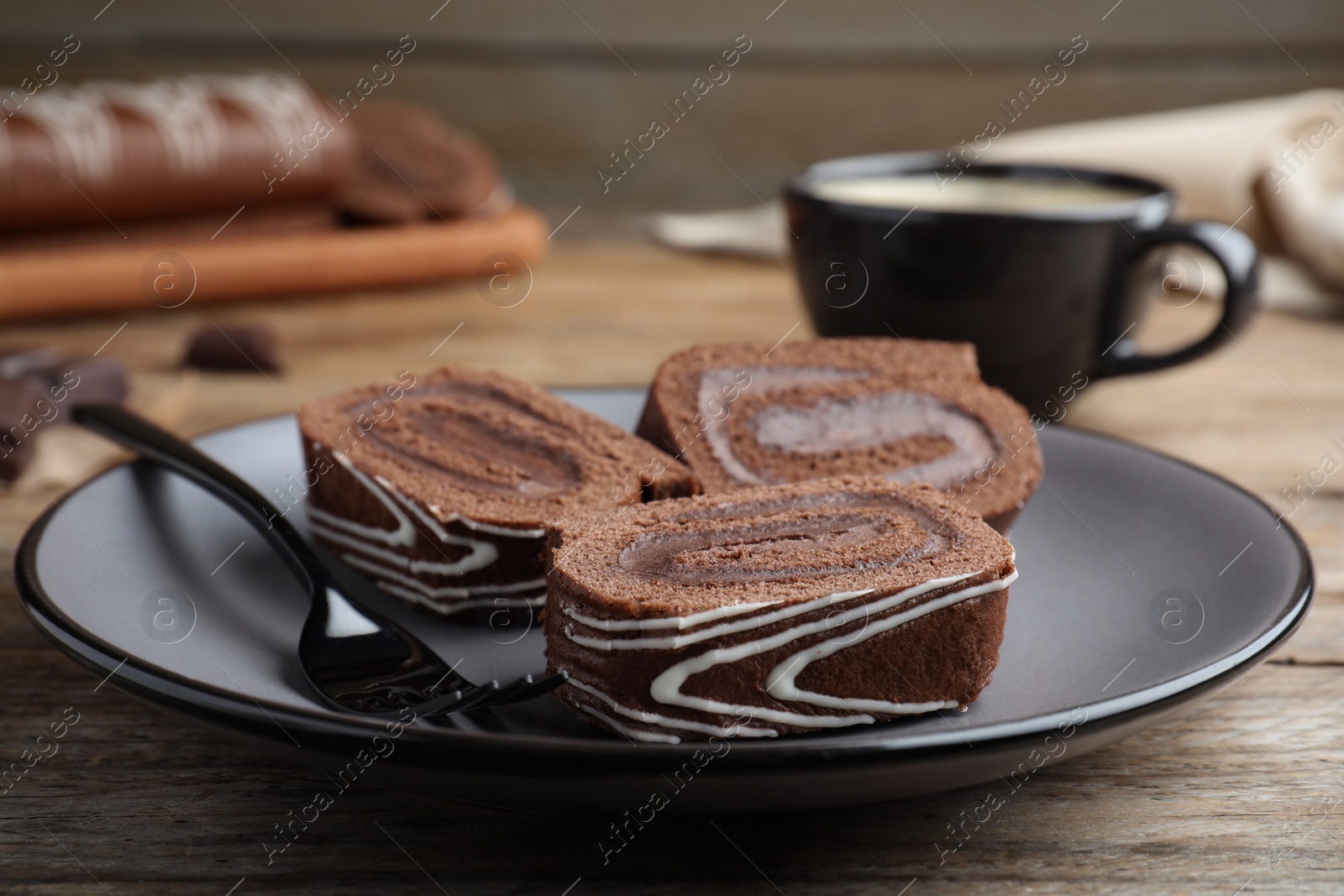 Photo of Tasty chocolate cake roll with cream on wooden table, closeup