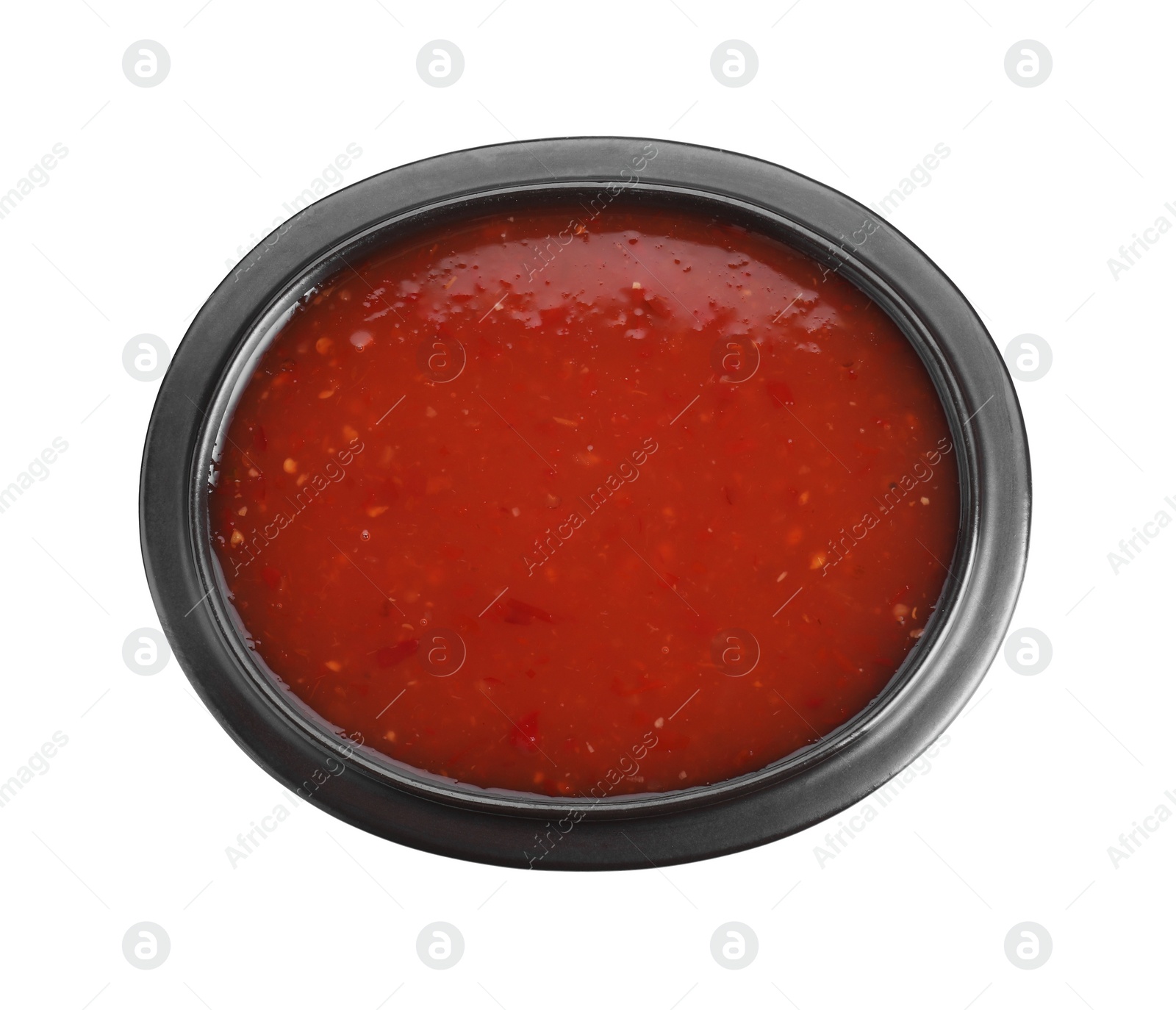 Photo of Spicy chili sauce in bowl isolated on white, top view