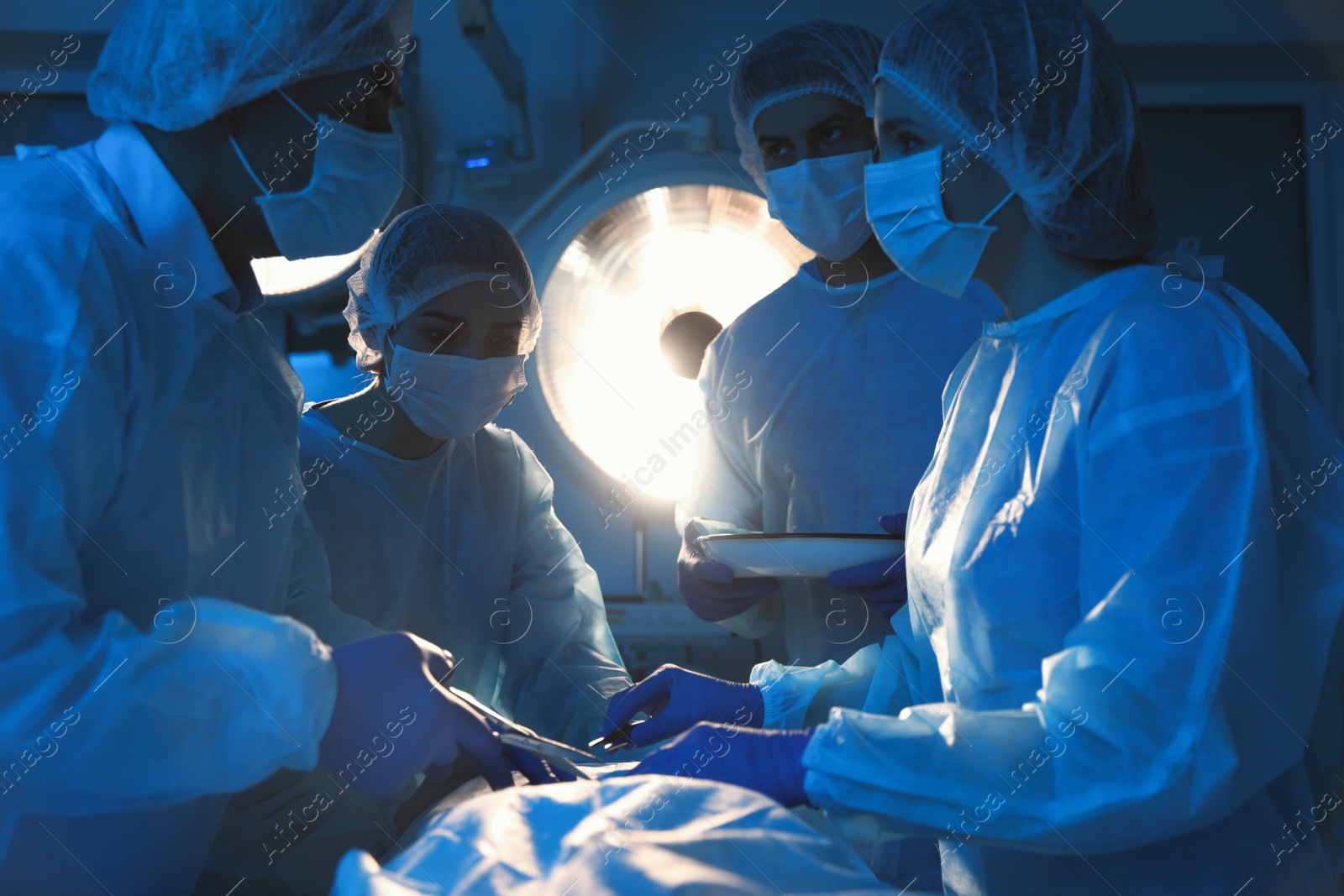 Photo of Team of professional doctors performing operation in surgery room