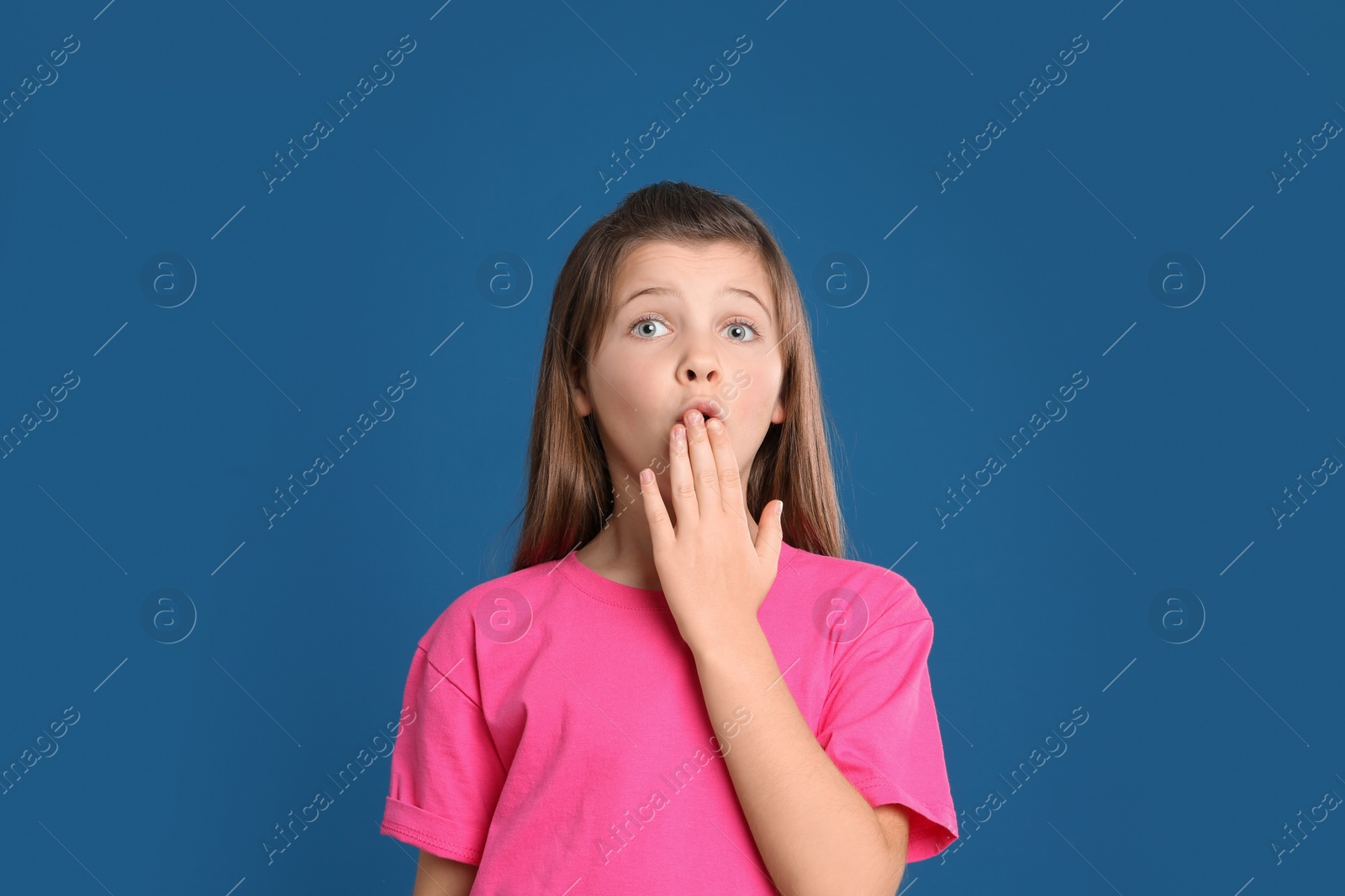 Photo of Portrait of emotional preteen girl on blue background