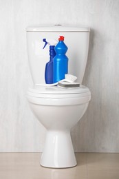 Photo of Different cleaning supplies on toilet bowl indoors