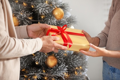 Photo of Happy couple holding Christmas gifts at home, closeup