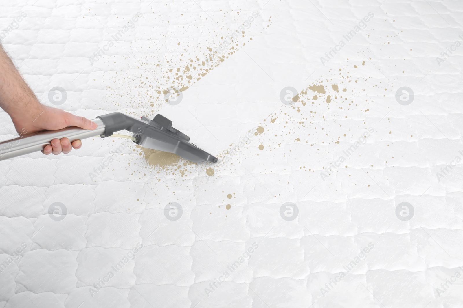 Image of Man disinfecting mattress with vacuum cleaner, closeup