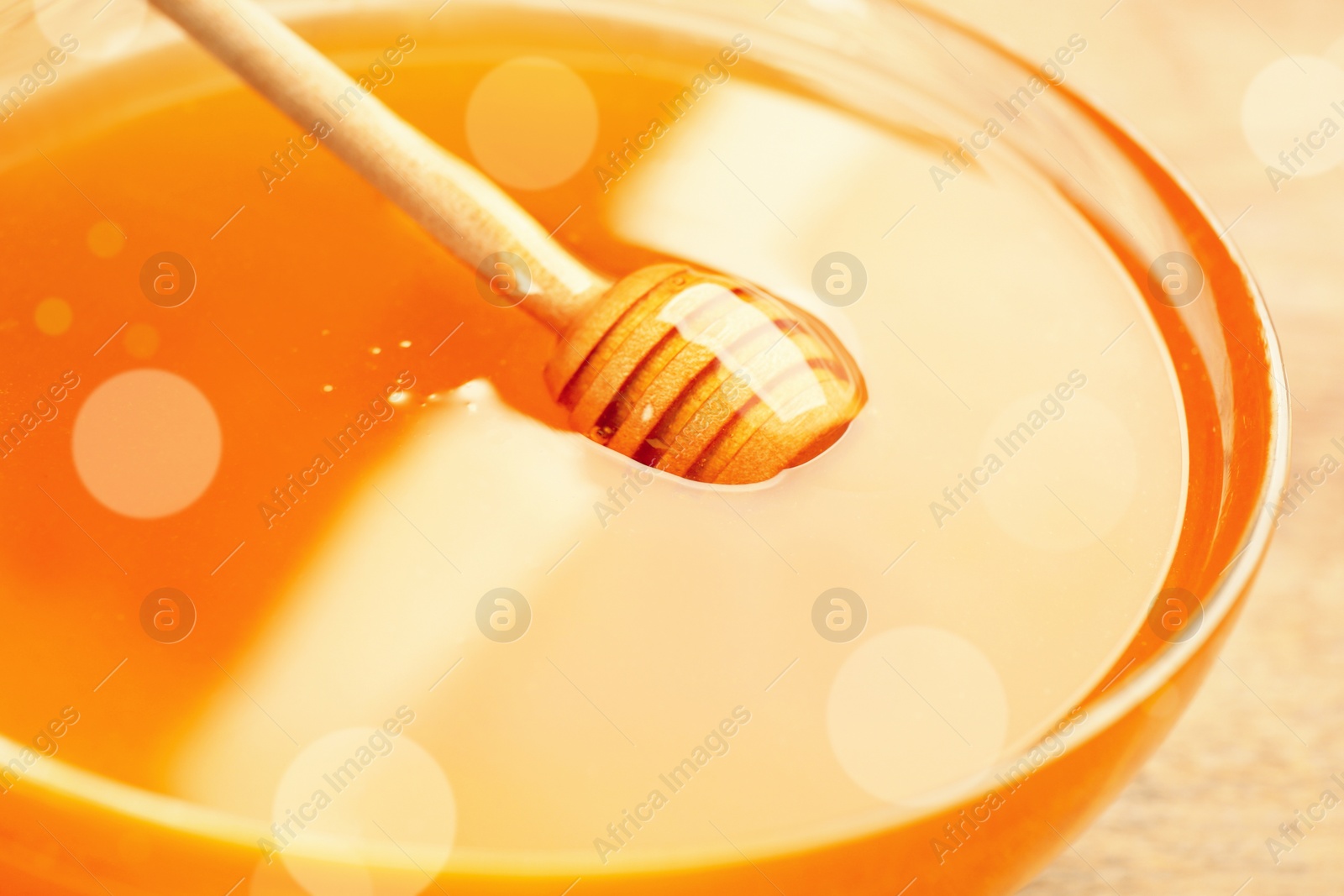 Image of Tasty honey in glass bowl on table, closeup