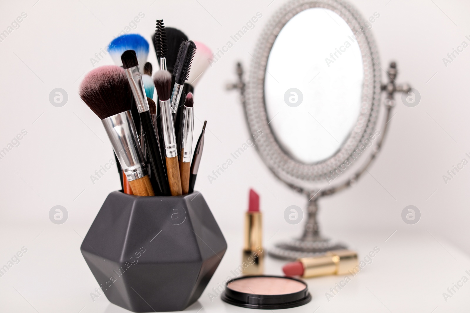 Photo of Holder with makeup brushes on table