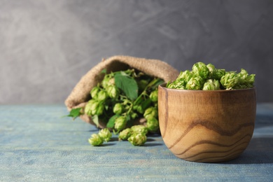 Photo of Bowl with fresh green hops on wooden table. Beer production