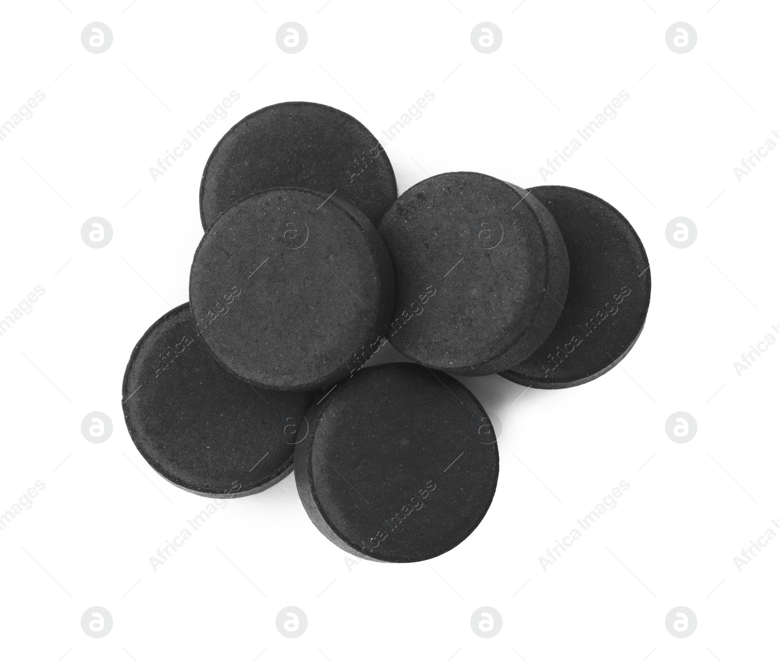 Photo of Activated charcoal pills on white background, top view. Potent sorbent