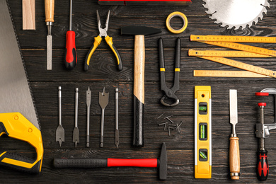 Flat lay composition with carpenter's tools on black wooden background