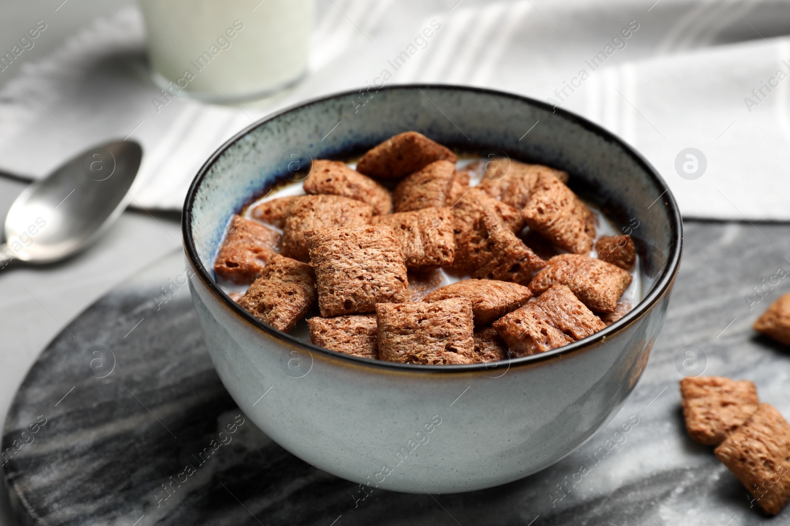 Photo of Bowl with tasty corn pads and milk on table, closeup