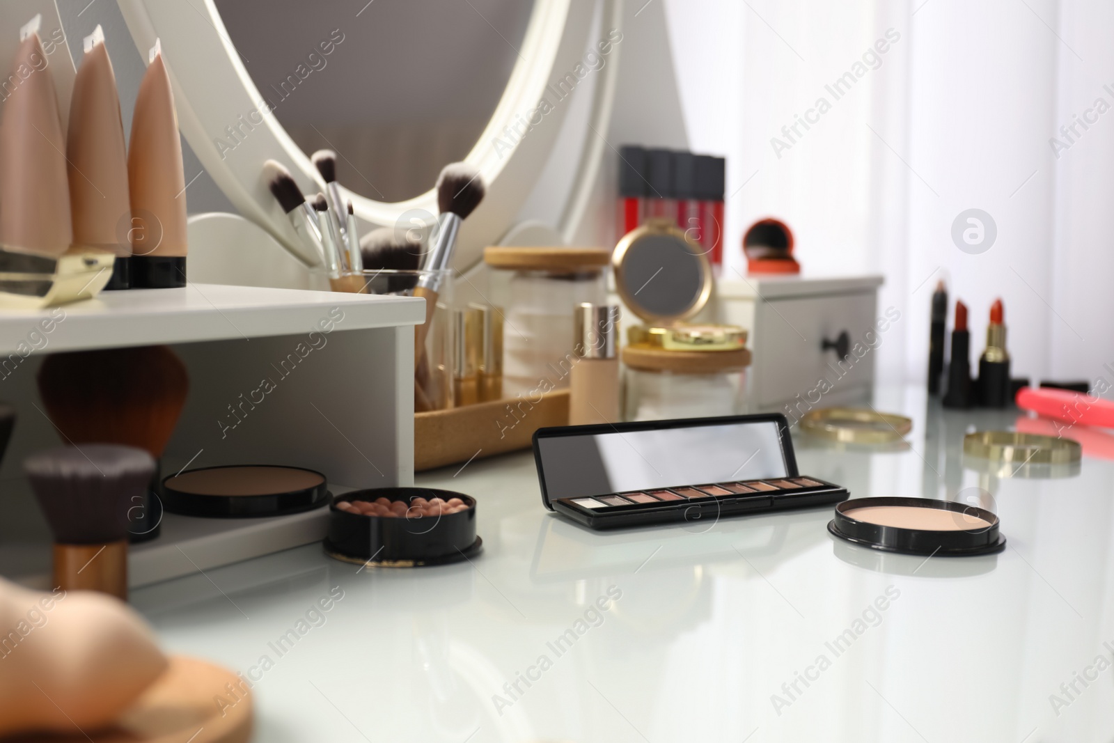 Photo of Many different cosmetic products on dressing table indoors