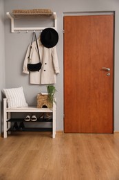 Modern hallway interior with stylish furniture near wooden door