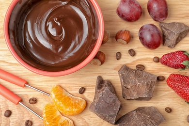 Photo of Flat lay composition with chocolate fondue on wooden background