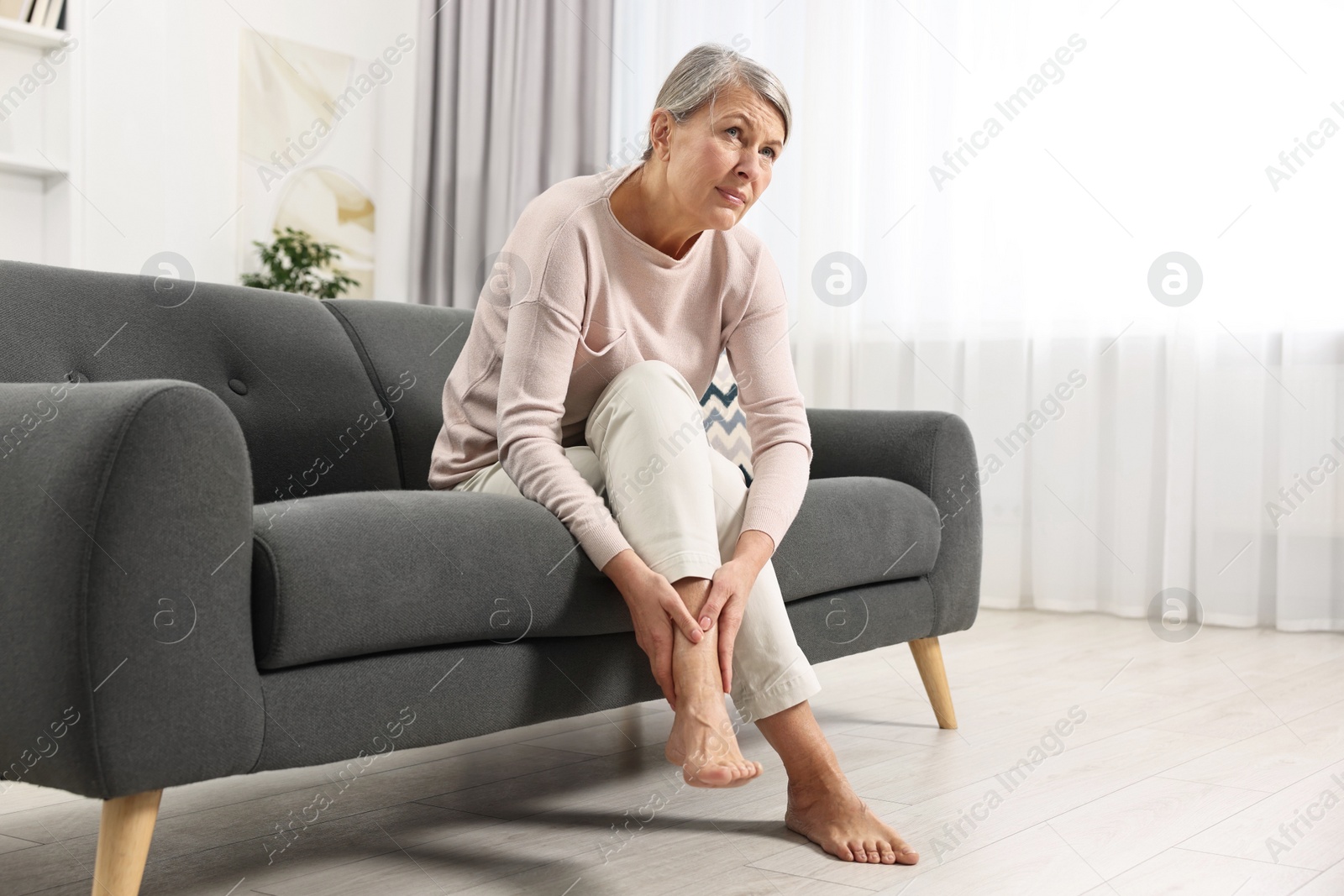 Photo of Arthritis symptoms. Woman suffering from pain in leg at home