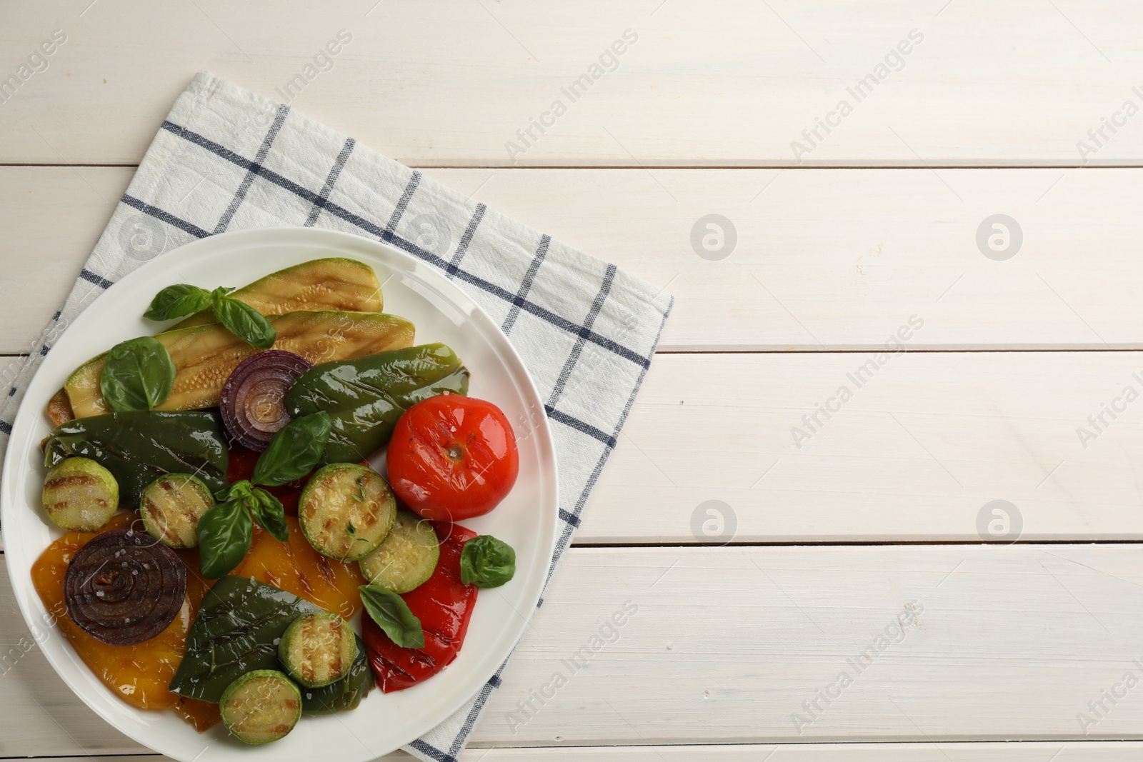 Photo of Delicious grilled vegetables on white wooden table, top view. Space for text
