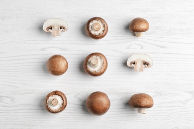 Photo of Flat lay composition with fresh champignon mushrooms on wooden table