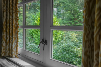 Photo of Old fashioned window with beautiful curtains in room. Interior design