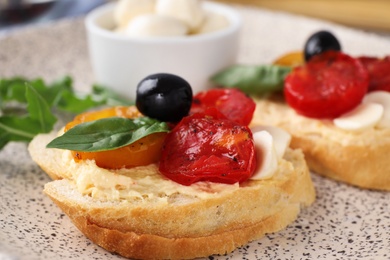 Photo of Delicious tomato bruschettas on ceramic plate, closeup