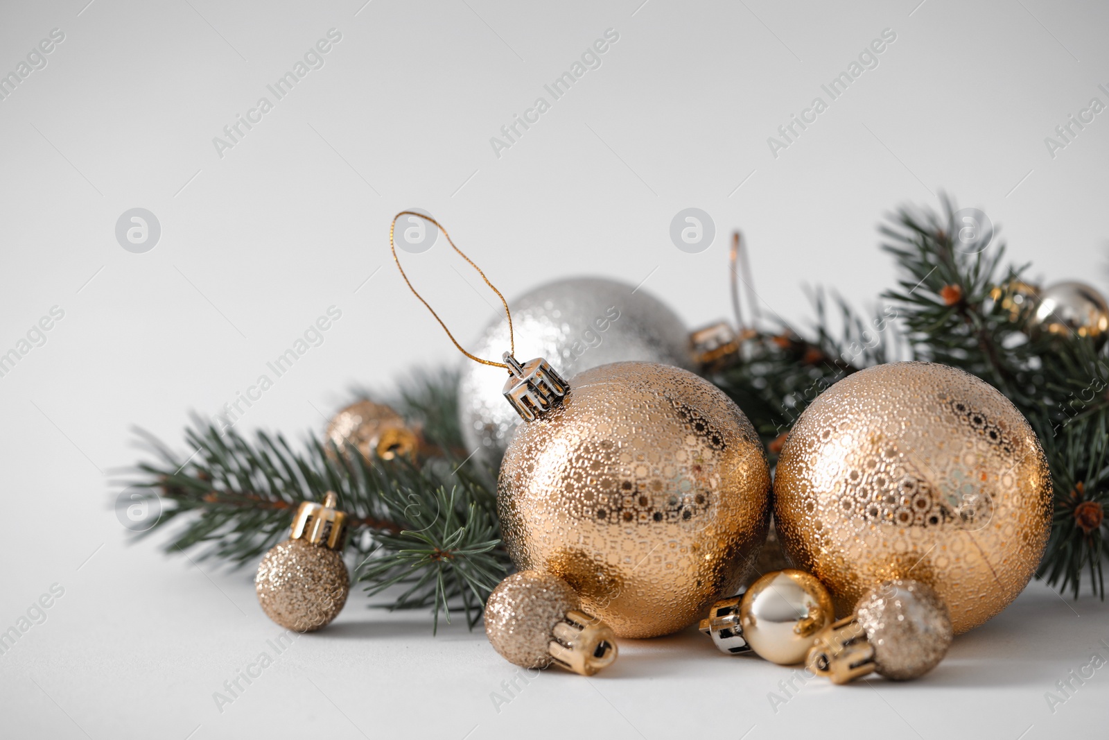 Photo of Beautiful Christmas balls and fir branches on white background