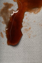 Photo of Dirty jacket with stain of coffee as background, top view