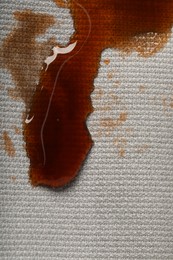 Dirty jacket with stain of coffee as background, top view