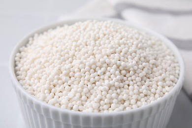 Photo of Tapioca pearls in bowl on white table, closeup