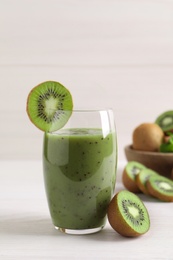 Photo of Delicious kiwi smoothie and fresh fruits on white wooden table