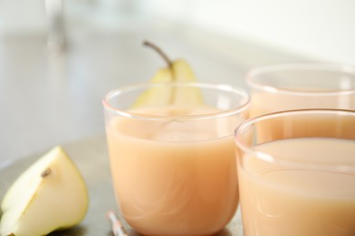 Photo of Glasses of tasty fresh pear juice, closeup