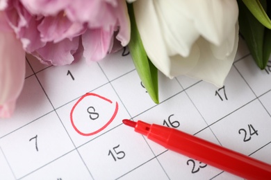 Photo of Tulips and red marker on calendar near date 8th of March, closeup. International Women's Day