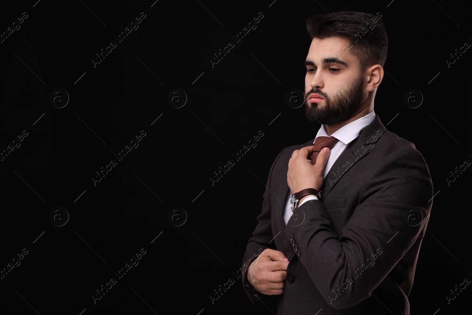 Photo of Handsome businessman in suit and necktie on black background. Space for text