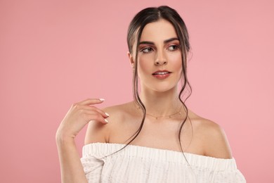 Photo of Beautiful woman with elegant necklace on pink background