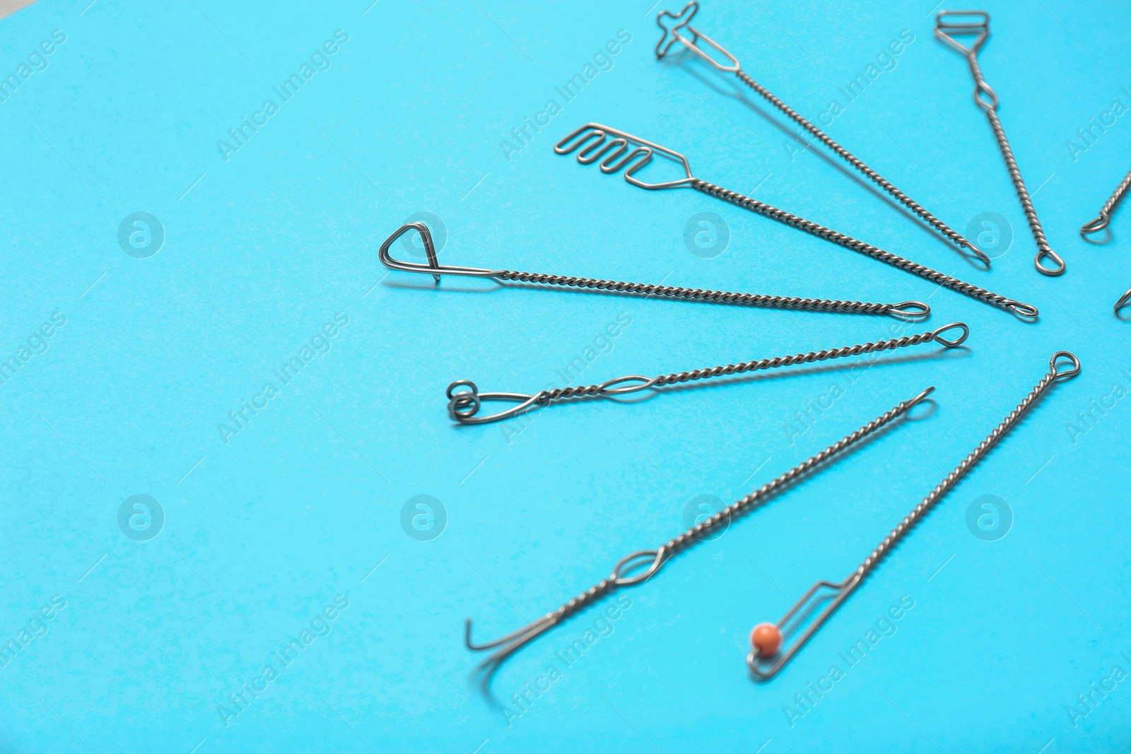 Photo of Set of logopedic probes for speech therapy on light blue background