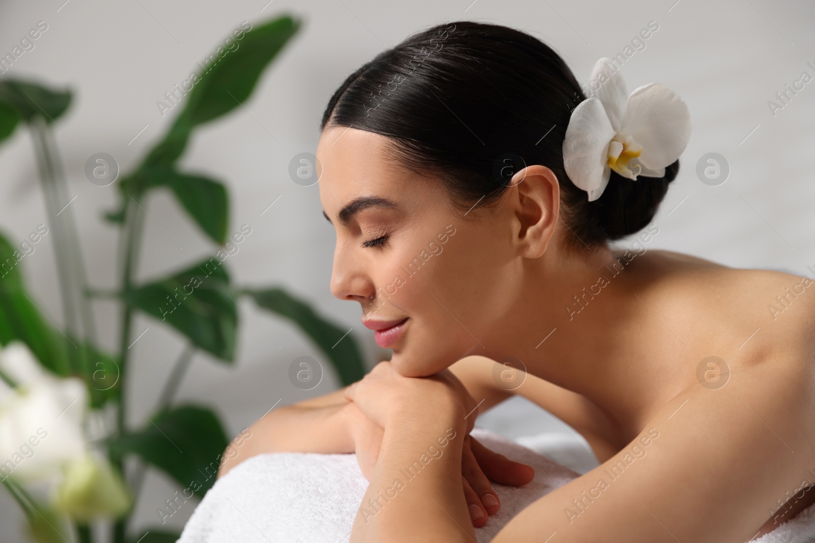 Photo of Beautiful woman relaxing on massage table in spa salon