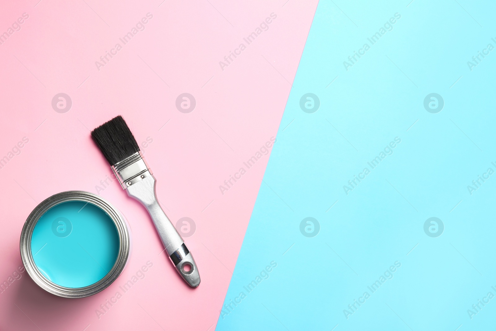 Photo of Open paint can, brush and space for text on color background, top view