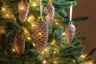 Photo of Christmas tree decorated with holiday baubles and fairy lights, closeup