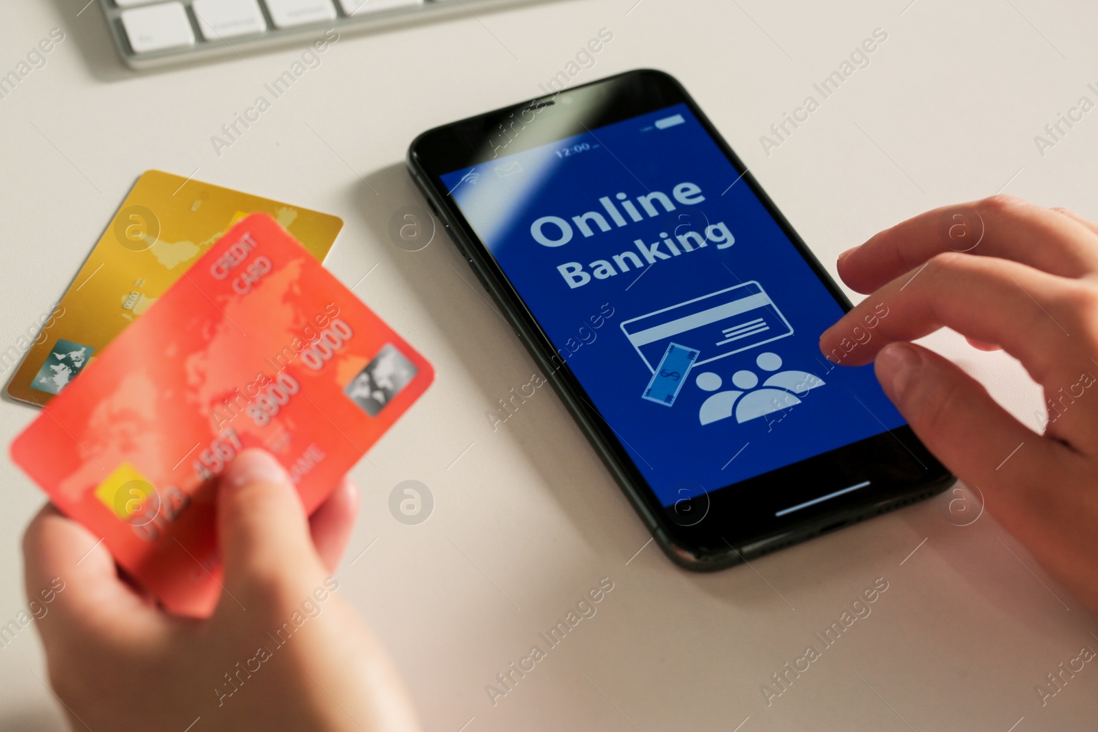 Photo of Woman using online banking app on smartphone and credit card at white office table, closeup