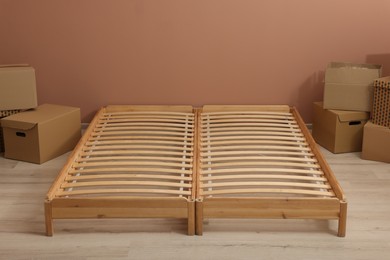 Photo of Wooden bed frame and cardboard boxes on floor in room