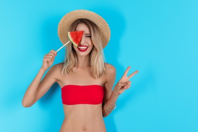 Pretty young woman with juicy watermelon on color background