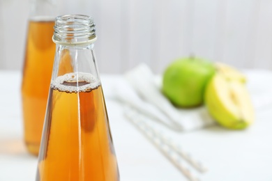 Photo of Bottle of fresh apple juice on table, closeup