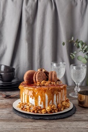 Delicious homemade cake with caramel sauce and popcorn on table