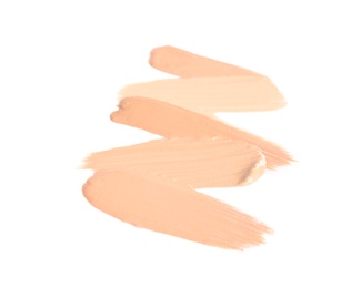 Samples of different foundation shades on white background, top view