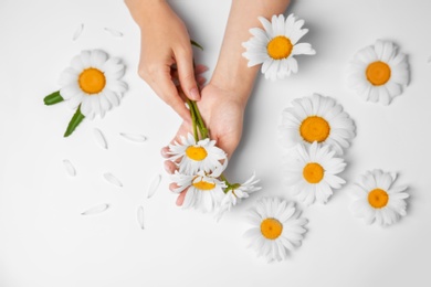 Photo of Woman with beautiful chamomile flowers on white background