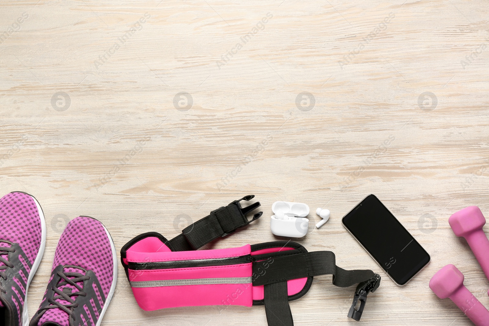 Photo of Flat lay composition with pink waist bag on white wooden table, space for text