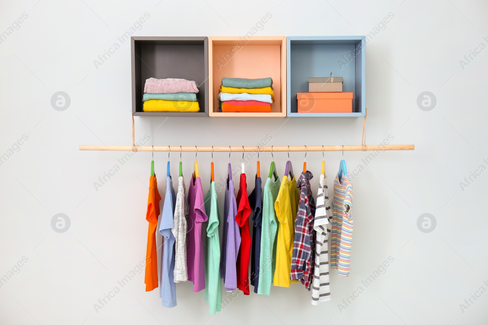 Photo of Rack with different clothes on light background