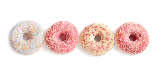 Photo of Delicious glazed doughnuts with sprinkles on light background, top view