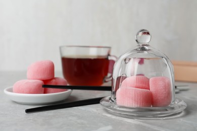 Photo of Glass cloche with delicious mochi on grey table, space for text. Traditional Japanese dessert